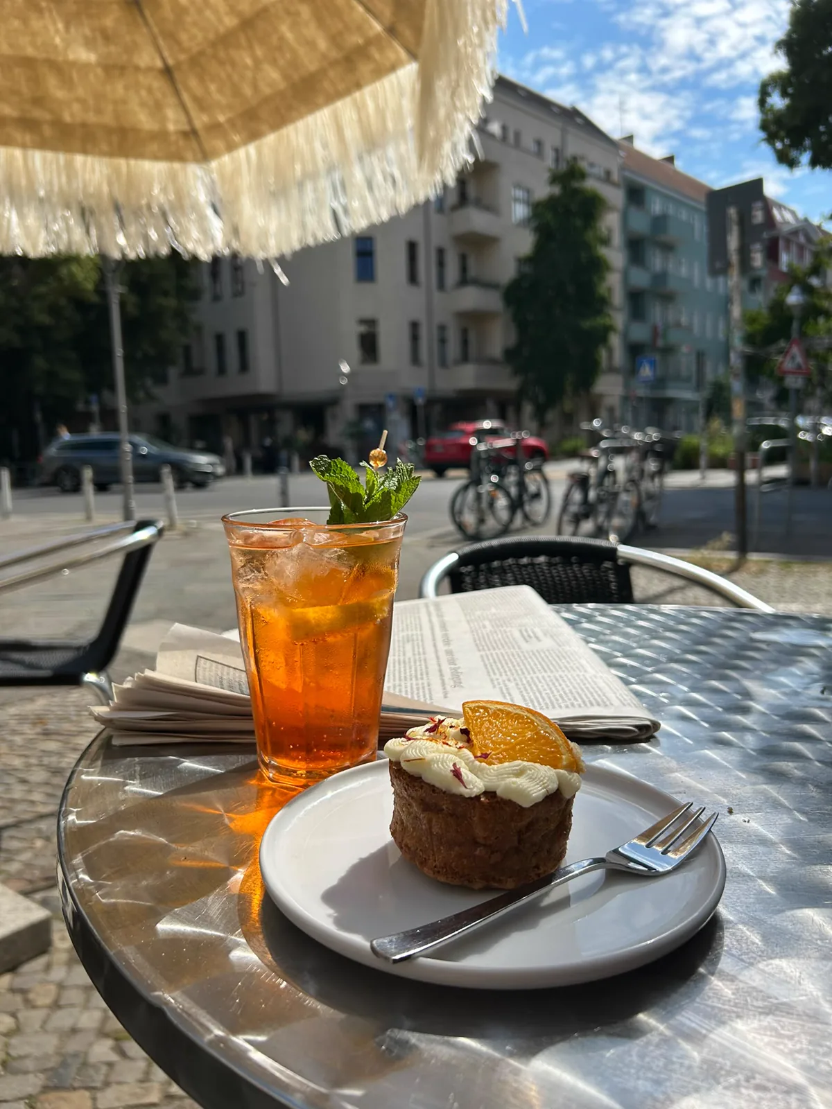 Aperol und Törtchen in der Sonne vor der Konditorei