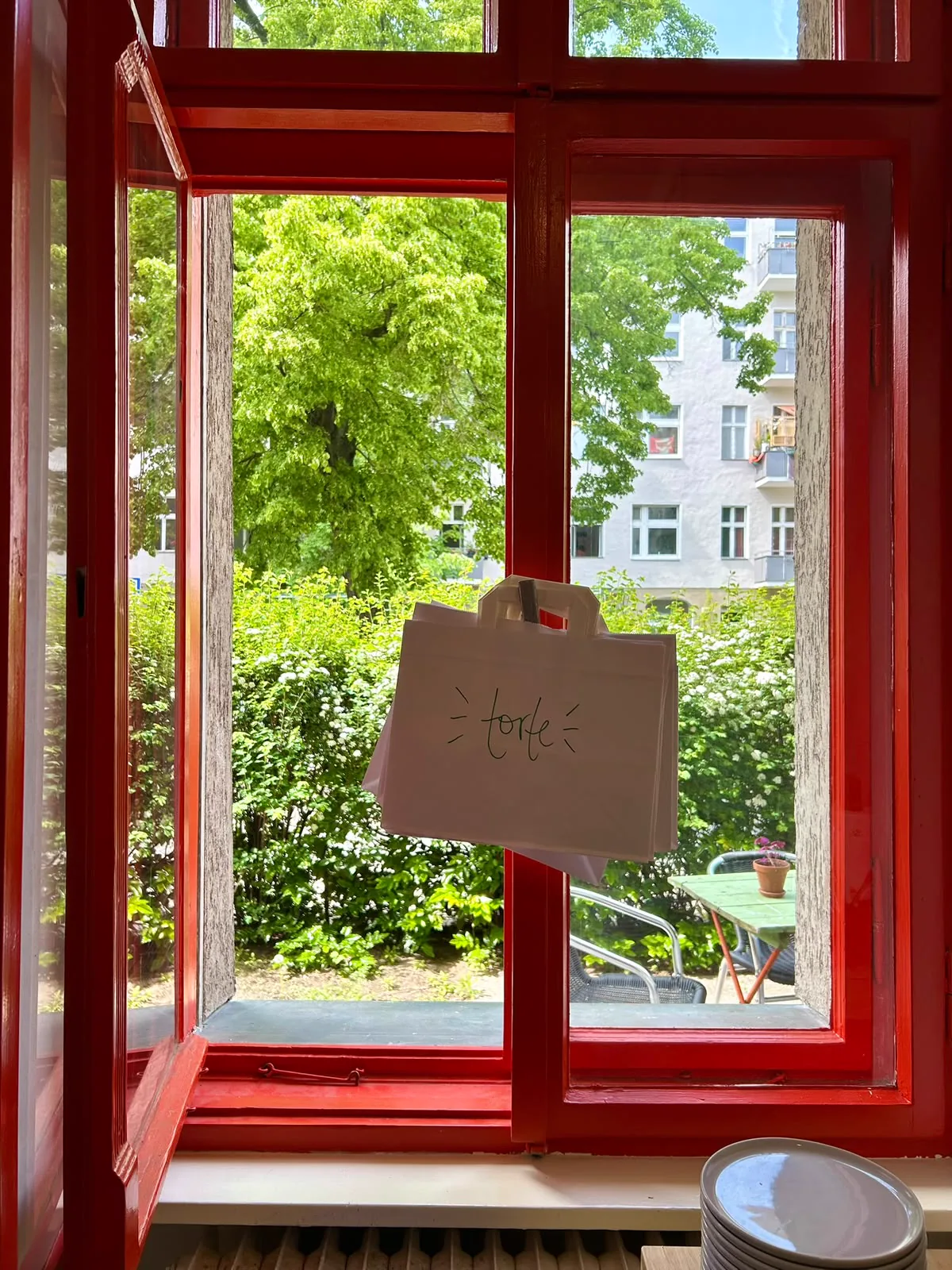 Eine Torte-Tüte am geöffneten roten Fenster