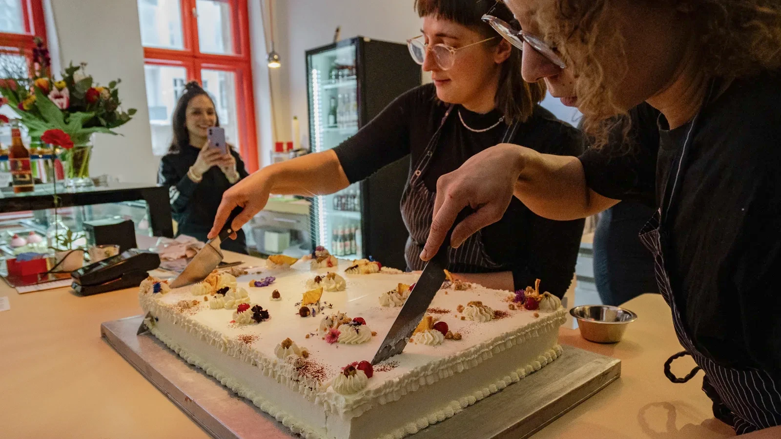 Menschen schneiden gemeinsam eine Torte an